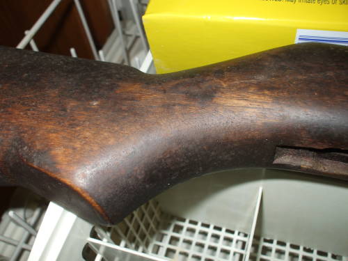 Dishwasher cleaning of an M1 Garand rifle stock. Dark and dirty wood before cleaning.