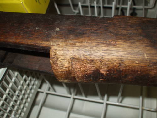Dishwasher cleaning of an M1 Garand rifle stock. Dark and dirty wood before cleaning.